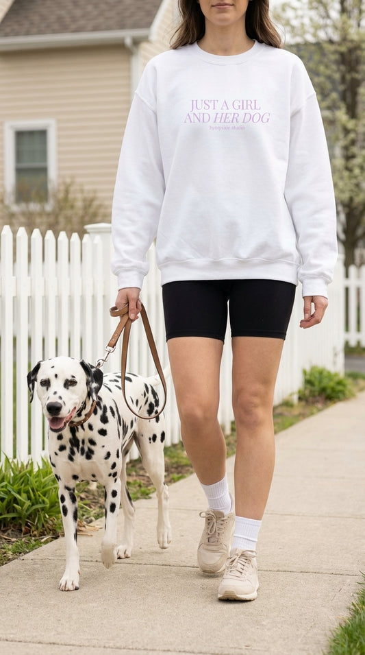 Person walking a Dalmatian dog on a leash with a white sweatshirt and black shorts.