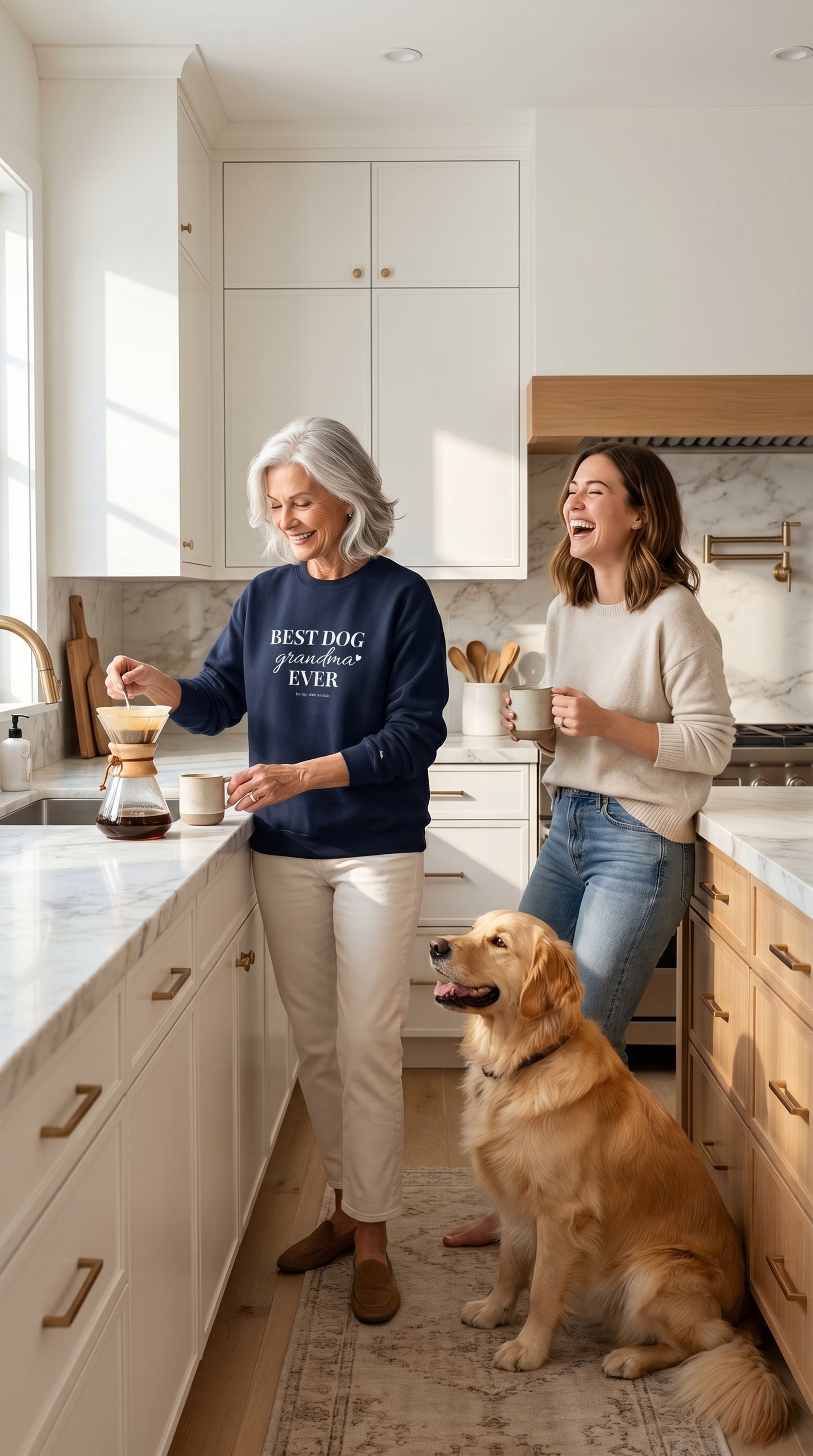 Older woman wearing a Best Dog Grandma crewneck making coffee in a bright kitchen beside a younger woman and a dog in a warm morning setting.
