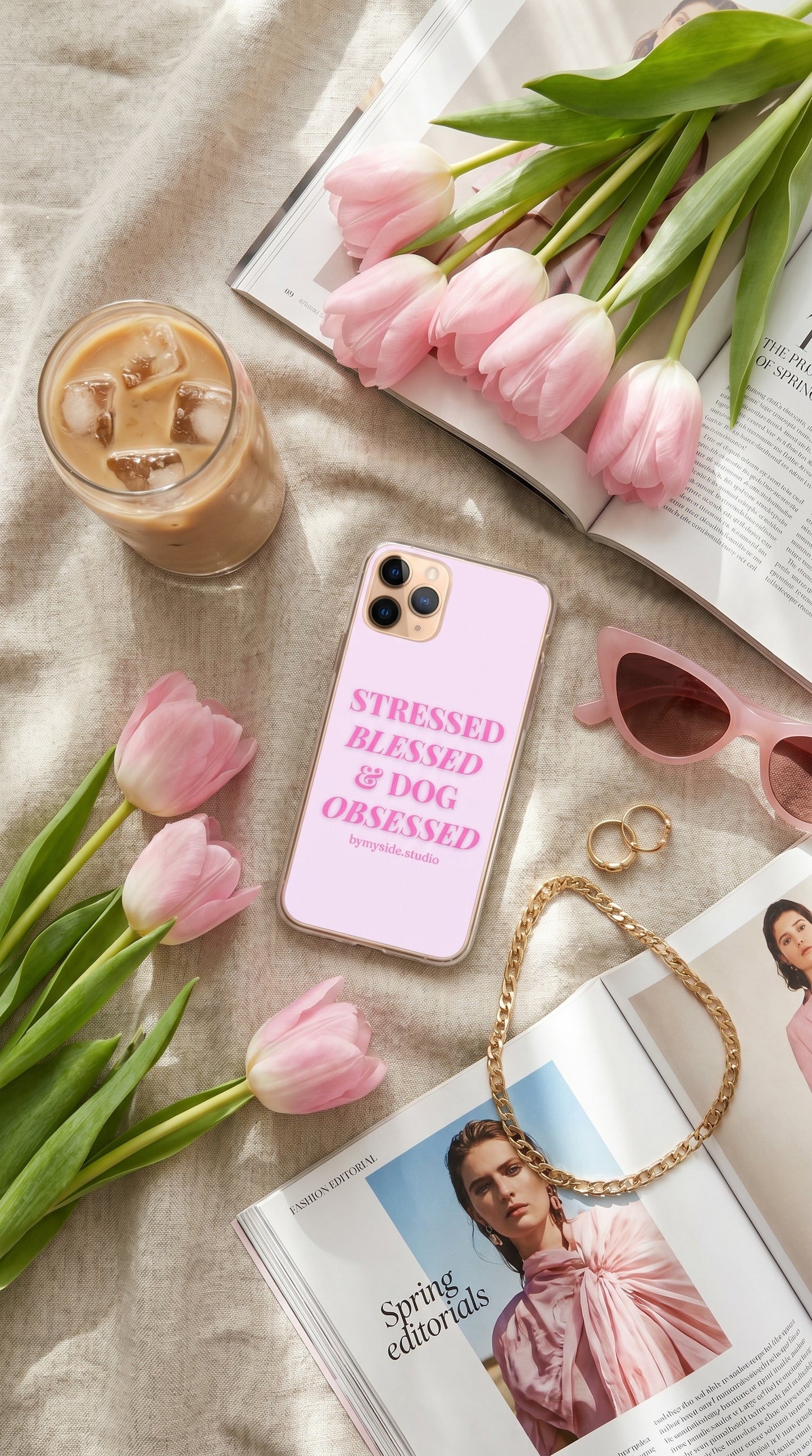 Spring picnic aesthetic featuring a pastel pink dog mom iPhone case beside pastries, flowers, and a dog outdoors.