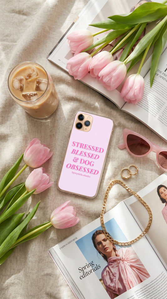 Spring picnic aesthetic featuring a pastel pink dog mom iPhone case beside pastries, flowers, and a dog outdoors.