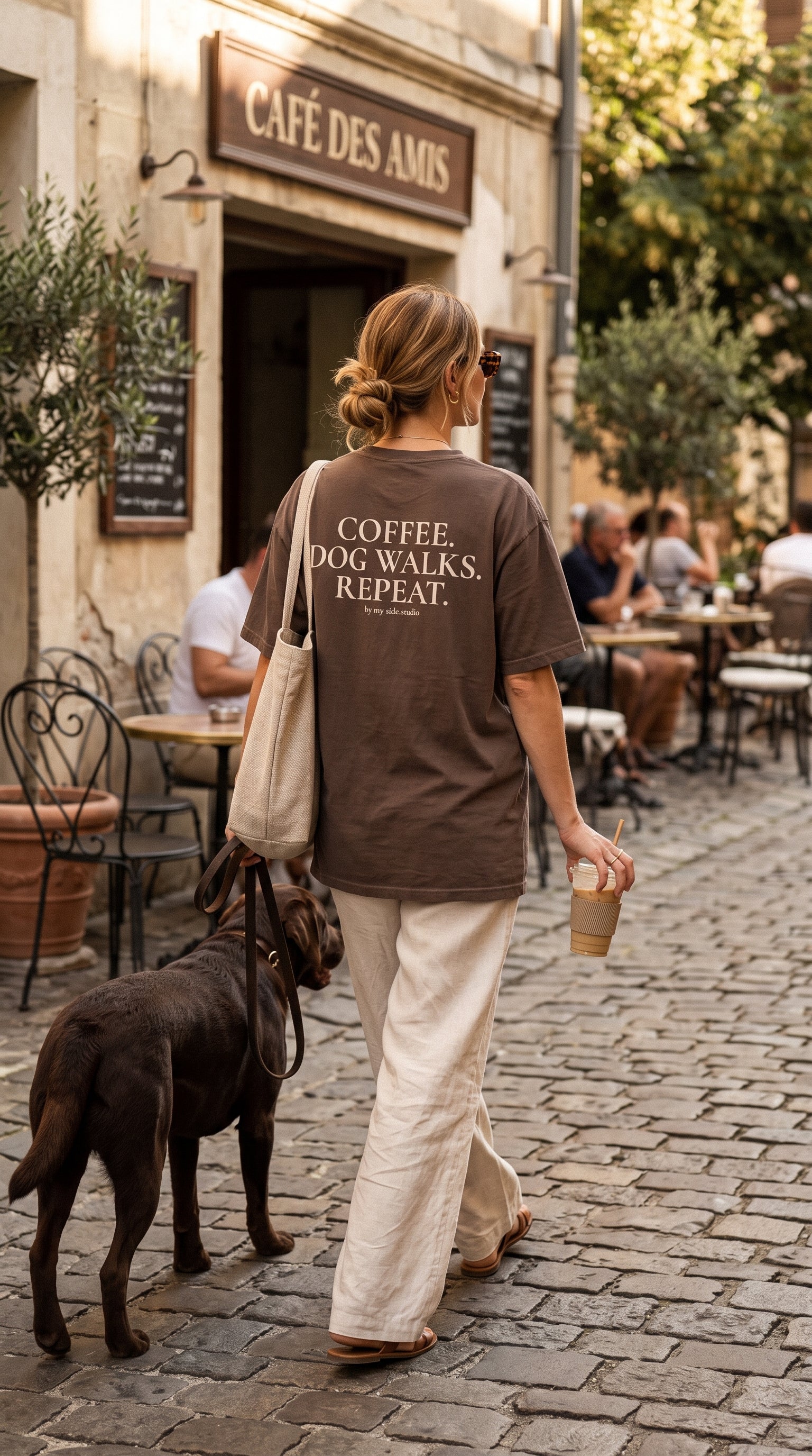 Coffee, dog walks and repeat women walking in coffee shop with her chocolate labrador dog